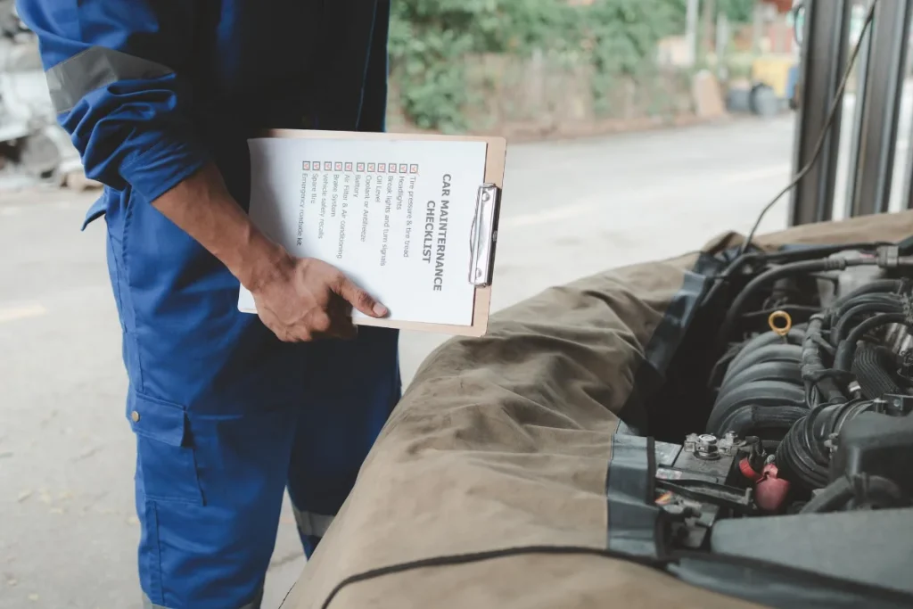 Mechanic with checklist inspecting a car